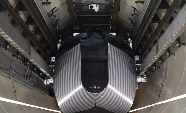 A test vehicle levitated by magnetic fields zips through a depressurized tube in a testing ground for a high-speed transit system during a press tour of an European test center for hyperloop transportation technology in Veendam, northern Netherlands, Friday, Sept. 6, 2024. (AP Photo/Peter Dejong)