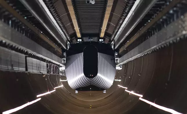 A test vehicle levitated by magnetic fields zips through a depressurized tube in a testing ground for a high-speed transit system during a press tour of a European test center for hyperloop transportation technology in Veendam, northern Netherlands, Friday, Sept. 6, 2024. (AP Photo/Peter Dejong)