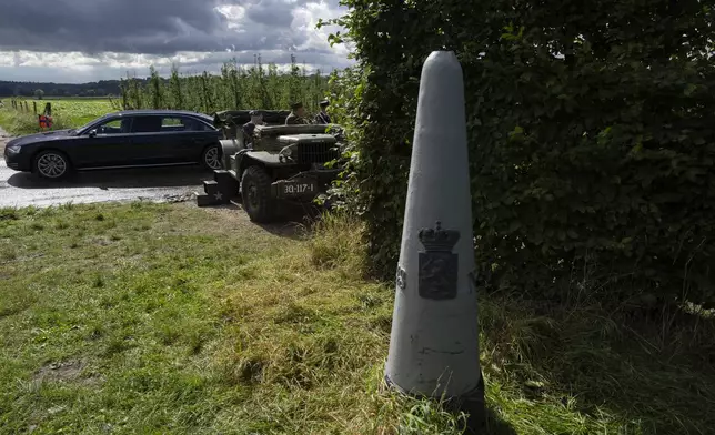 A border marker is seen as Dutch King Willem-Alexander and Queen Maxima arrive by limousine to join World War II veteran Kenneth Thayer, waiting in a jeep, during a ceremony marking the 80th anniversary of the liberation of the south of the Netherlands in Mesch, Thursday, Sept. 12, 2024. (AP Photo/Peter Dejong, Pool)