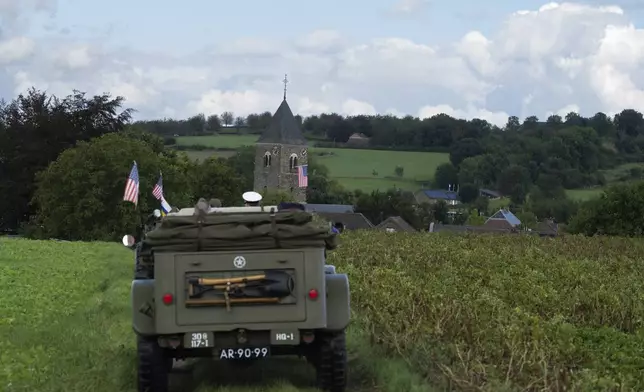 An American flag flies from the bell tower of the church as a convoy of WWII vehicles drives the liberation route during a ceremony marking the 80th anniversary of the liberation of the south of the Netherlands in Mesch, Thursday, Sept. 12, 2024. (AP Photo/Peter Dejong, Pool)