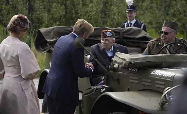 World War II veteran Kenneth Thayer is greeted by Dutch King Willem-Alexander and Queen Maxima before the royals joined Thayer in the jeep during a ceremony marking the 80th anniversary of the liberation of the south of the Netherlands in Mesch, Thursday, Sept. 12, 2024. (AP Photo/Peter Dejong, Pool)