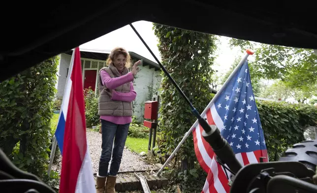 A resident waves as a jeep passes during a ceremony marking the 80th anniversary of the liberation of the south of the Netherlands in Mesch, Thursday, Sept. 12, 2024. (AP Photo/Peter Dejong, Pool)