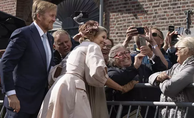 Dutch King Willem-Alexander and Queen Maxima pose for a selfie with a well-wisher during a ceremony marking the 80th anniversary of the liberation of the south of the Netherlands in Mesch, Thursday, Sept. 12, 2024. (AP Photo/Peter Dejong)