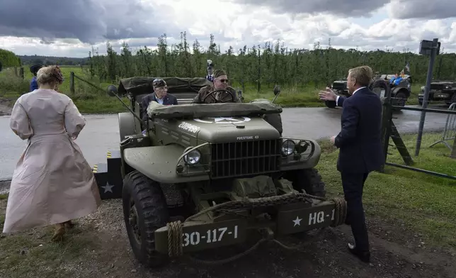 World War II veteran Kenneth Thayer, seated left, is greeted by Dutch King Willem-Alexander and Queen Maxima before the royals joined Thayer in the jeep during a ceremony marking the 80th anniversary of the liberation of the south of the Netherlands in Mesch, Thursday, Sept. 12, 2024. (AP Photo/Peter Dejong, Pool)