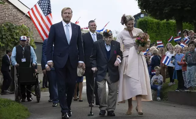 World War II veteran Kenneth Thayer is escorted by Dutch King Willem-Alexander and Queen Maxima during a ceremony marking the 80th anniversary of the liberation of the south of the Netherlands in Mesch, Thursday, Sept. 12, 2024. (AP Photo/Peter Dejong)