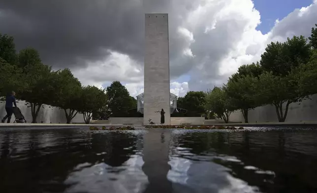 Eighty years after the liberation of the south of the Netherlands a visitor pushes a stroller at the Netherlands American Cemetery in Margraten, southern Netherlands, on Wednesday, Sept. 11, 2024. (AP Photo/Peter Dejong)