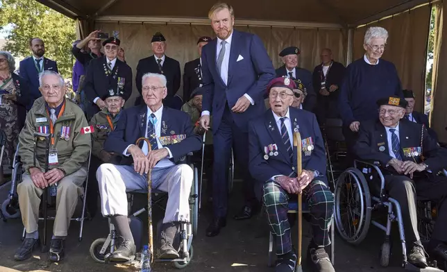 Kink Willem Alexander of the Netherlands, center, meets some surviving veterans in Ginkel Heath Netherlands, Saturday, Sept. 21, 2024, to mark the 80th anniversary of an audacious by unsuccessful World War II mission codenamed Market Garden to take key bridges in the Netherlands. (AP Photo/Phil Nijhuis)