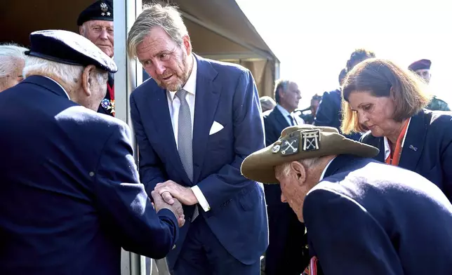 King Willem Alexander of the Netherlands, center, meets some surviving veterans in Ginkel Heath Netherlands, Saturday, Sept. 21, 2024, to mark the 80th anniversary of an audacious by unsuccessful World War II mission codenamed Market Garden to take key bridges in the Netherlands. (AP Photo/Phil Nijhuis)