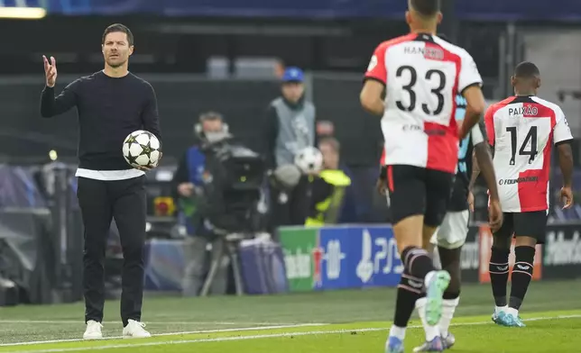 Leverkusen's head coach Xabi Alonso holds the ball during the Champions League opening phase soccer match between Feyenoord and Leverkusen in Rotterdam, Netherlands, Thursday, Sept. 19, 2024. (AP Photo/Peter Dejong)