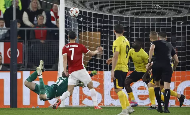 Elfsborg's goalkeeper Isak Pettersson dives but fails to save the goal from AZ Alkmaar's Ruben van Bommel, centre, during the Europa League soccer match between AZ Alkmaar and Elfsborg at the AFAS stadium, in Alkmaar, Netherlands, Wednesday, Oct. 25, 2024. (AP Photo/Maurice van Steen)