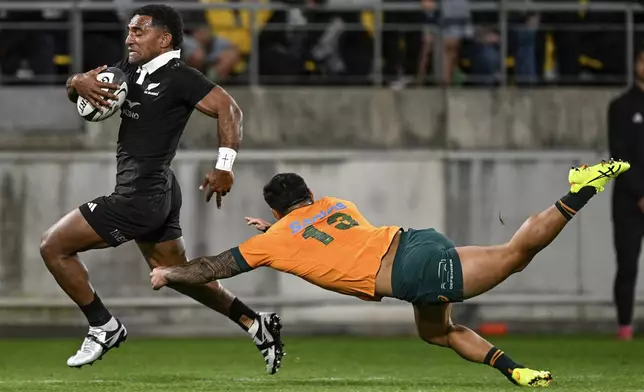 New Zealand's Sevu Reece runs past Australia's Len Ikitau to score a try during their Rugby Championship match between the All Blacks and the Wallabies in Wellington, New Zealand, Saturday, Sept. 28, 2024.(Andrew Cornaga/Photosport via AP)