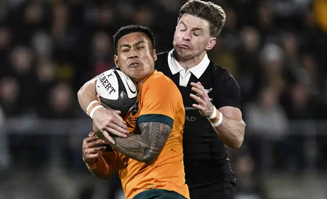 Australia's Len Ikitau is tackled by New Zealand's Beauden Barrett, right, during their Rugby Championship match between the All Blacks and the Wallabies in Wellington, New Zealand, Saturday, Sept. 28, 2024.(Andrew Cornaga/Photosport via AP)