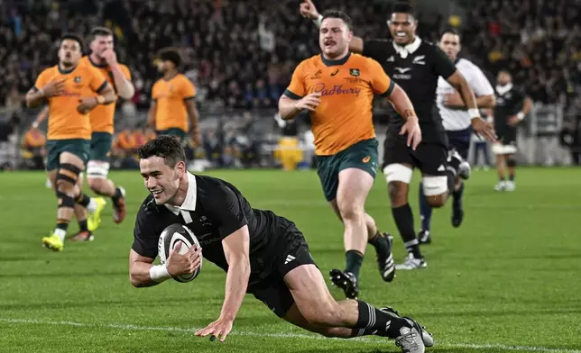 New Zealand's Will Jordan scores a try during their Rugby Championship match between the All Blacks and the Wallabies in Wellington, New Zealand, Saturday, Sept. 28, 2024.(Andrew Cornaga/Photosport via AP)