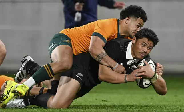 New Zealand's Caleb Clarke scores a try as he is tackled by Australia's Hunter Paisami during their Rugby Championship match between the All Blacks and the Wallabies in Wellington, New Zealand, Saturday, Sept. 28, 2024.(Andrew Cornaga/Photosport via AP)