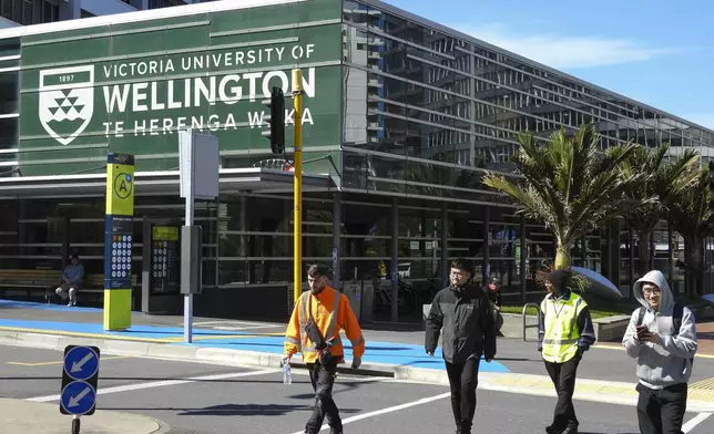 People walk past the name of Victoria University of Wellington, written in English and Maori languages as New Zealand celebrates its annual Maori language week in Wellington, New Zealand, Wednesday, Sept. 18, 2024. (AP Photo/Charlotte GrahamMcLay)