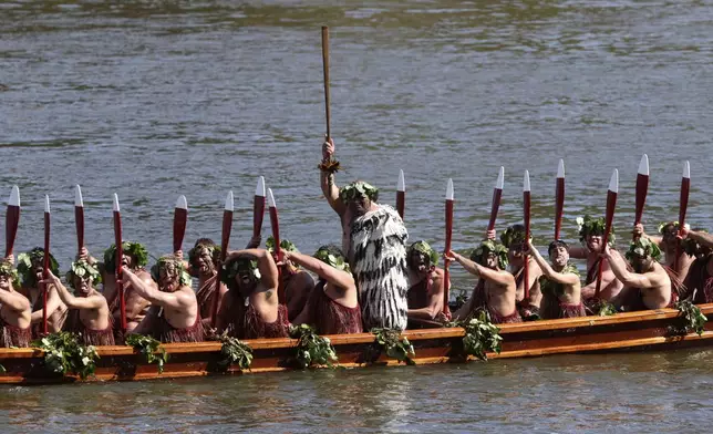 A waka, a traditional canoe, is paddled by warriors as part of the funeral of New Zealand's Maori King, Kiingi Tuheitia Pootatau Te Wherowhero VII, in Ngaruawahia, New Zealand, Thursday, Sept. 5, 2024. (AP Photo/Alan Gibson)