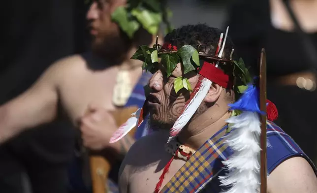 A warrior waits for the arrival of the coffin of New Zealand's Maori King, Kiingi Tuheitia Pootatau Te Wherowhero VII, before the burial in Ngaruawahia, New Zealand, Thursday, Sept. 5, 2024. (AP Photo/Alan Gibson)