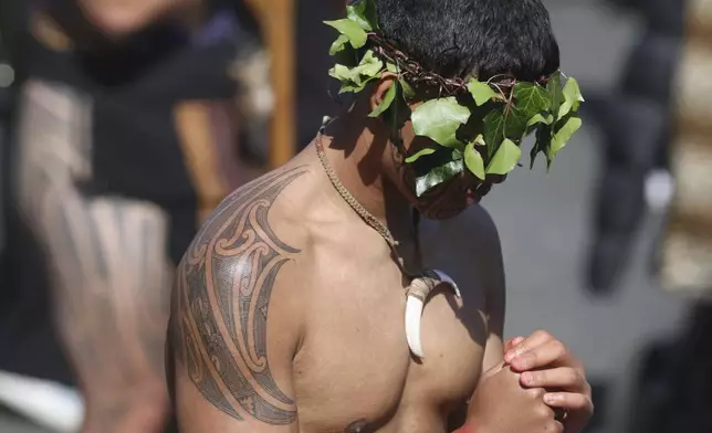 A warrior waits for the arrival of the coffin of New Zealand's Maori King, Kiingi Tuheitia Pootatau Te Wherowhero VII, before the burial in Ngaruawahia, New Zealand, Thursday, Sept. 5, 2024. (AP Photo/Alan Gibson)