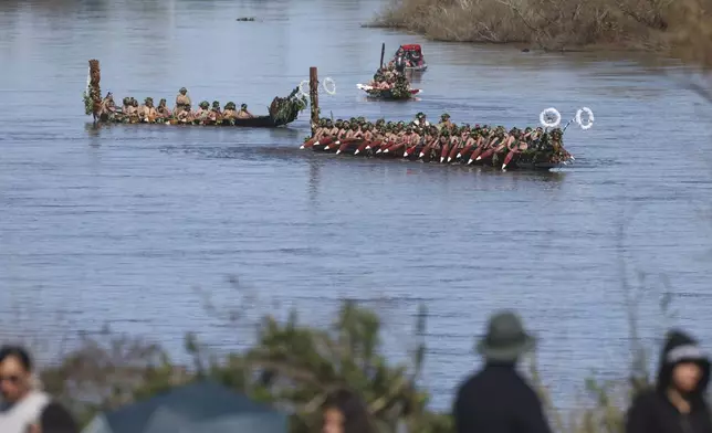 Wakas, a traditional canoe, are paddled by warriors as part of the funeral of New Zealand's Maori King, Kiingi Tuheitia Pootatau Te Wherowhero VII, in Ngaruawahia, New Zealand, Thursday, Sept. 5, 2024. (AP Photo/Alan Gibson)