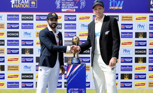 Sri Lanka's captain Dhananjaya de Silva, left, and New Zealand's captain Tim Southee pose for a photograph with the trophy before the start of the first day of the cricket test match between New Zealand and Sri Lanka in Galle, Sri Lanka, Wednesday, Sept. 18, 2024. (AP Photo/Viraj Kothalawala)