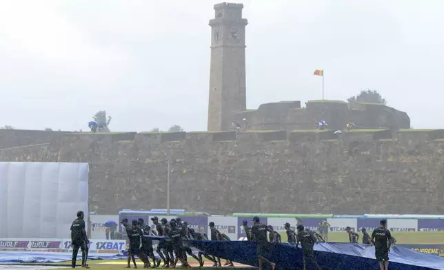 Groundsmen pull the covers on as rain disrupts play on the second day of the first cricket test match between New Zealand and Sri Lanka in Galle, Sri Lanka, Thursday, Sept. 19, 2024. (AP Photo/Viraj Kothalawala)