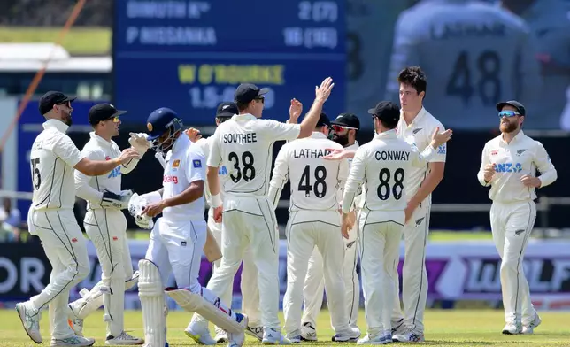 New Zealand's players congratulate New Zealand's William O'Rourke, second right, for taking the wicket of Sri Lanka's Dimuth Karunaratne on the first day of the first cricket test match between New Zealand and Sri Lanka in Galle, Sri Lanka, Wednesday, Sept. 18, 2024. (AP Photo/Viraj Kothalawala)