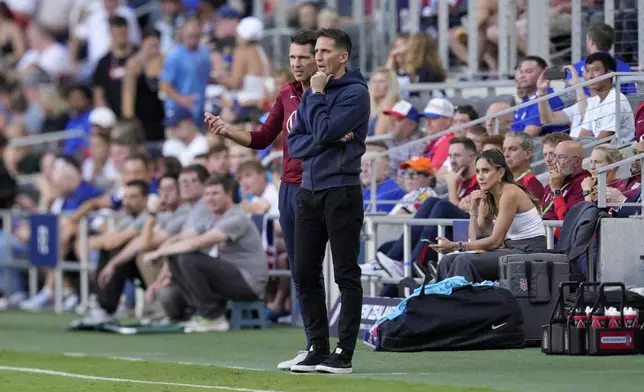 United States interim head coach Mikey Varas, center right, speaks with a member of his staff in the technical area during the first half of a friendly soccer match against New Zealand, Tuesday, Sept. 10, 2024, in Cincinnati. (AP Photo/Jeff Dean)