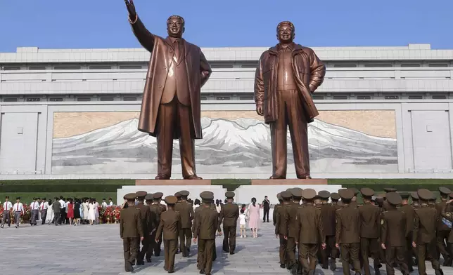 Pyongyang citizens pay respect to the statues of their late leaders Kim Il Sung, left, and Kim Jong Il on Mansu Hill on the occasion of the country's 76th founding anniversary in Pyongyang, North Korea Monday, Sept. 9, 2024. (AP Photo/Cha Song Ho)