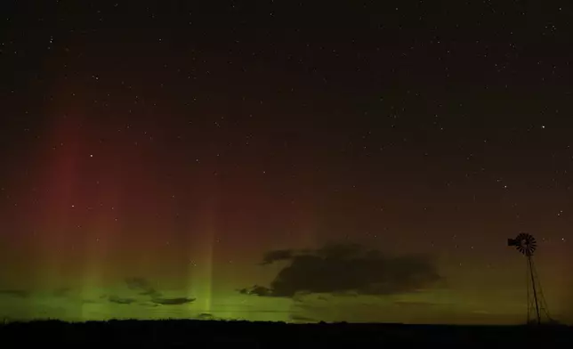 An aurora borealis, also known as the northern lights, is seen in the night sky behind a windmill water pump on Tuesday, Sept. 24, 2024, near Washtucna, Wash. (AP Photo/Ted S. Warren)