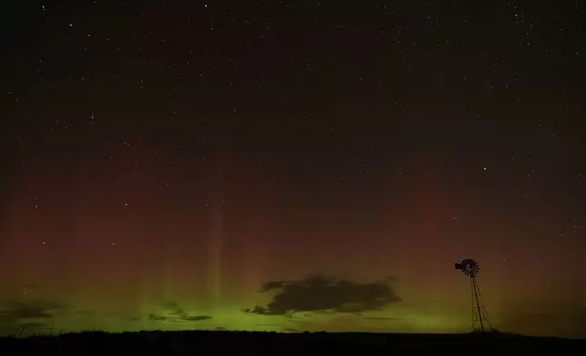 An aurora borealis, also known as the northern lights, is seen in the night sky behind a windmill water pump on Tuesday, Sept. 24, 2024, near Washtucna, Wash. (AP Photo/Ted S. Warren)