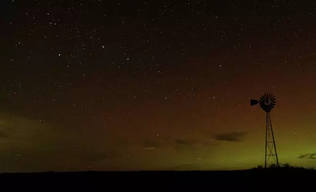 An aurora borealis, also known as the northern lights, is seen in the night sky with the Big Dipper constellation behind a windmill water pump on Tuesday, Sept. 24, 2024, near Washtucna, Wash. (AP Photo/Ted S. Warren)