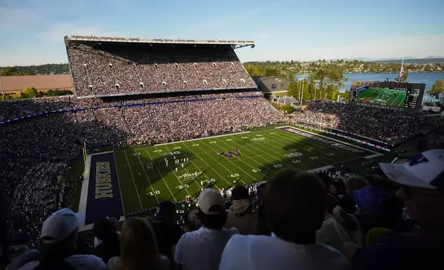 Fans watch from the upper concourse during the first half of an NCAA college football game between Washington and Northwestern, Saturday, Sept. 21, 2024, in Seattle. (AP Photo/Lindsey Wasson)