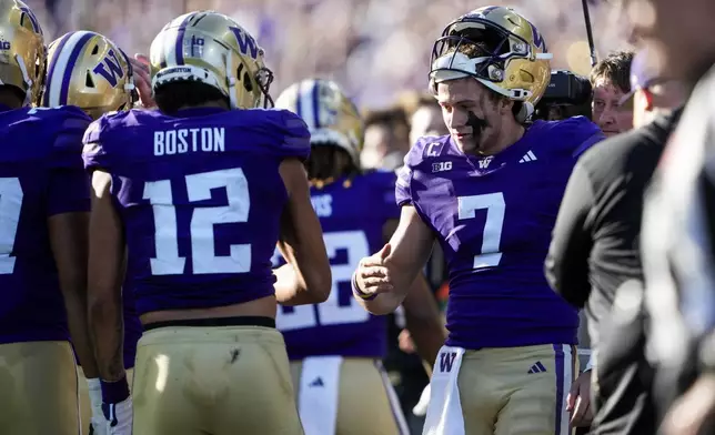 Washington quarterback Will Rogers (7) greets wide receiver Denzel Boston (12) after throwing a touchdown pass to Boston during the first half of an NCAA college football game against Northwestern, Saturday, Sept. 21, 2024, in Seattle. (AP Photo/Lindsey Wasson)