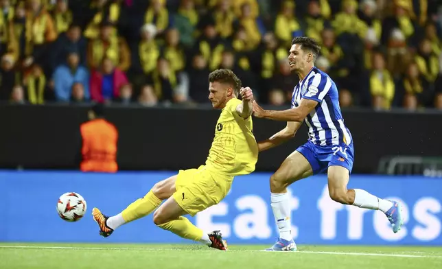 Glimt's Kasper Høgh, left, scores his side's opening goal during the Europa League opening phase soccer match between Bodø/Glimt and Porto, at the Aspmyra stadium, in Bodo, Norway, Wednesday, Sept. 25, 2024. (Mats Torbergsen/NTB Scanpix via AP)
