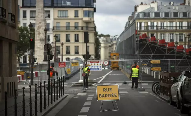 FILE - Security officers stand at the security perimeter of a closed street at the 2024 Summer Olympics, July 21, 2024, in Paris, France. (AP Photo/Thomas Padilla, File)