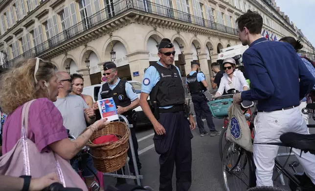 FILE - Police officers check authorizations at a checkpoint, July 18, 2024, in Paris. (AP Photo/David Goldman, File)