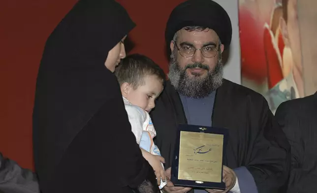 FILE - Hezbollah leader Hassan Nasrallah, hands a certificate to the wife of a slain Hezbollah fighter during a ceremony in Beirut's southern suburbs, Sunday April 8, 2007. (AP Photo, File)