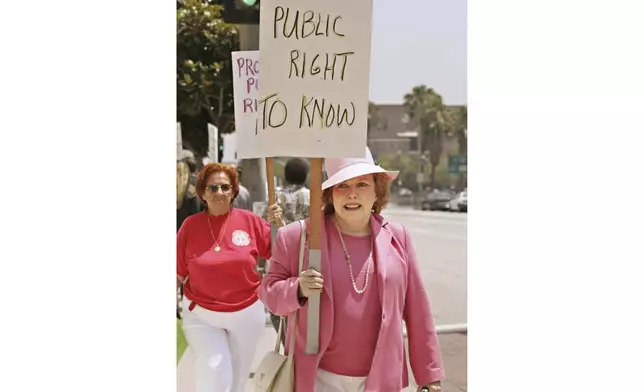 FILE - Associated Press reporter Linda Deutsch, right, and other journalists demonstrate in front of a federal courthouse in Los Angeles, July 6, 2005, in support of New York Times reporter Judith Miller, who were ordered to jail by a U.S. judge for refusing to divulge sources in the investigation of the leak of an undercover CIA officer's name. (AP Photo/Nick Ut, File)