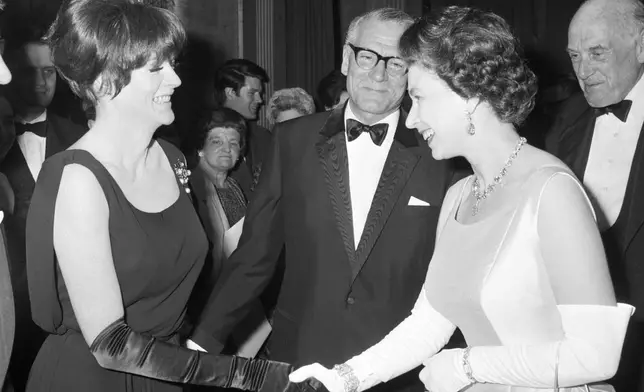 FILE - Britain's Queen Elizabeth II, right is introduced to Maggie Smith by Laurence Olivier, center, during the charity premiere for the film Othello, at the Odeon Theatre, London, May 2, 1966. Smith has died aged 89. (PA via AP, File)