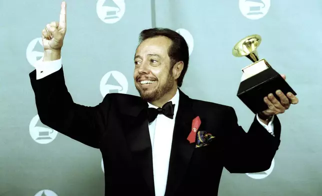 FILE - Sergio Mendes holds up his Gramophone trophy at the Grammy Awards show held at the Shrine Auditorium in Los Angeles, on Feb. 24, 1993. (AP Photo/Reed Saxon, File)