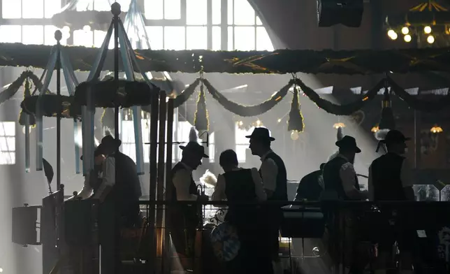 Bavarian musicians prepare in the Augustiner marquee for the start of the 189th 'Oktoberfest' beer festival in Munich, Germany, Saturday morning, Sept. 21, 2024. (AP Photo/Matthias Schrader)