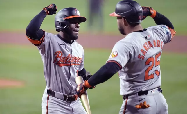 Baltimore Orioles' Cedric Mullins, left, is congratulated by Anthony Santander (25) after his solo home run in the first inning of a baseball game against the Boston Red Sox at Fenway Park, Tuesday, Sept. 10, 2024, in Boston. (AP Photo/Charles Krupa)