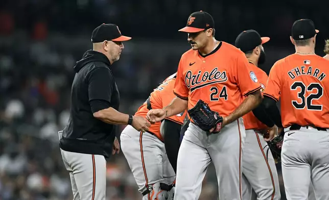 Baltimore Orioles manager Brandon Hyde, left, takes the ball from starting pitcher Zach Eflin (24) in the seventh inning of a baseball game against the Detroit Tigers, Friday, Sept. 13, 2024, in Detroit. (AP Photo/Jose Juarez)