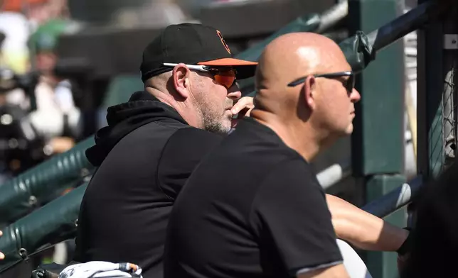 Baltimore Orioles manager Brandon Hyde, left, and head athletic trainer Brian Ebel, right, watch from the dugout in the third inning of a baseball game against the Detroit Tigers, Sunday, Sept. 15, 2024, in Detroit. (AP Photo/Jose Juarez)