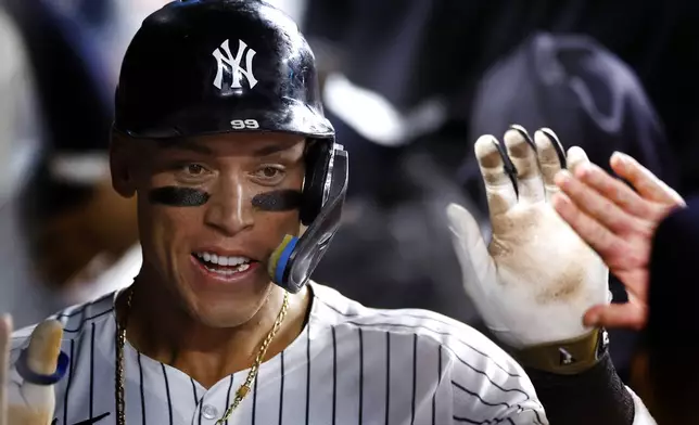 New York Yankees' Aaron Judge celebrates in the dugout after hitting a home run against the Baltimore Orioles during the seventh inning of a baseball game, Thursday, Sept. 26, 2024, in New York. (AP Photo/Noah K. Murray)