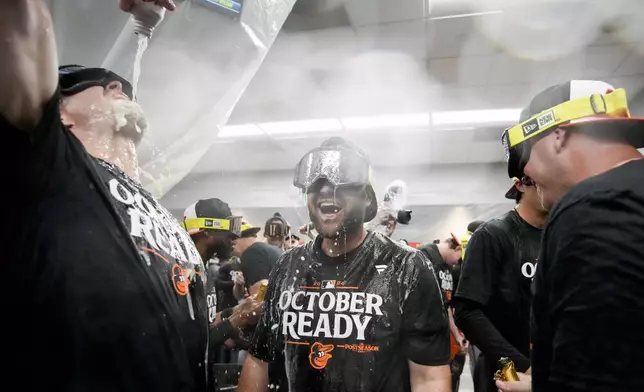 Baltimore Orioles' players celebrate after clinching a playoff berth by defeating the New York Yankees in baseball game, Tuesday, Sept. 24, 2024, in New York. (AP Photo/Bryan Woolston)