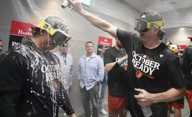 Baltimore Orioles' Jackson Holliday is doused with beer as teammates celebrate after clinching a playoff berth by defeating the New York Yankees in baseball game, Tuesday, Sept. 24, 2024, in New York. (AP Photo/Bryan Woolston)