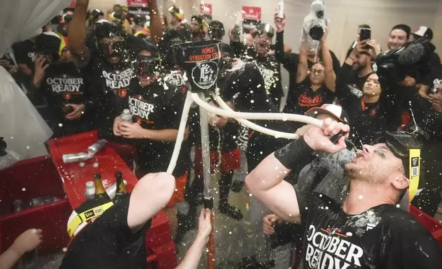 Baltimore Orioles' players celebrate after clinching a playoff berth by defeating the New York Yankees in baseball game, Tuesday, Sept. 24, 2024, in New York. (AP Photo/Bryan Woolston)