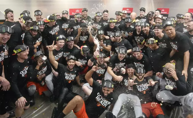 Baltimore Orioles' players celebrate after clinching a playoff berth by defeating the New York Yankees in baseball game, Tuesday, Sept. 24, 2024, in New York. (AP Photo/Bryan Woolston)