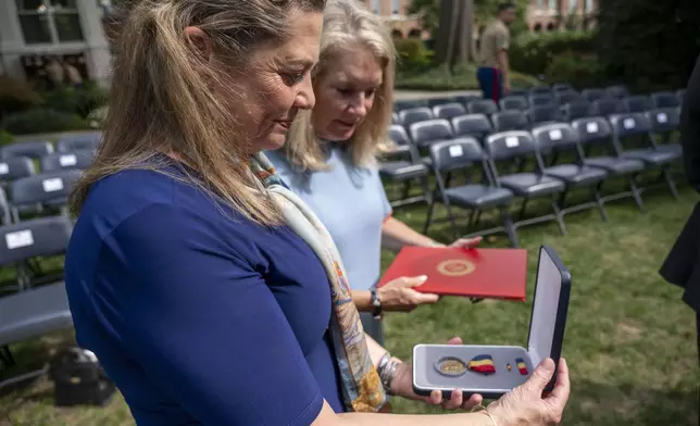 Alexia Collart, left, holds The Navy and Marine Corps Medal, the USMCs highest non-combat medal, that was posthumously awarded to her son, Cpl. Spencer Collart, during a ceremony on Monday, Sept. 16, 2024 in Washington. (AP Photo/Kevin Wolf)